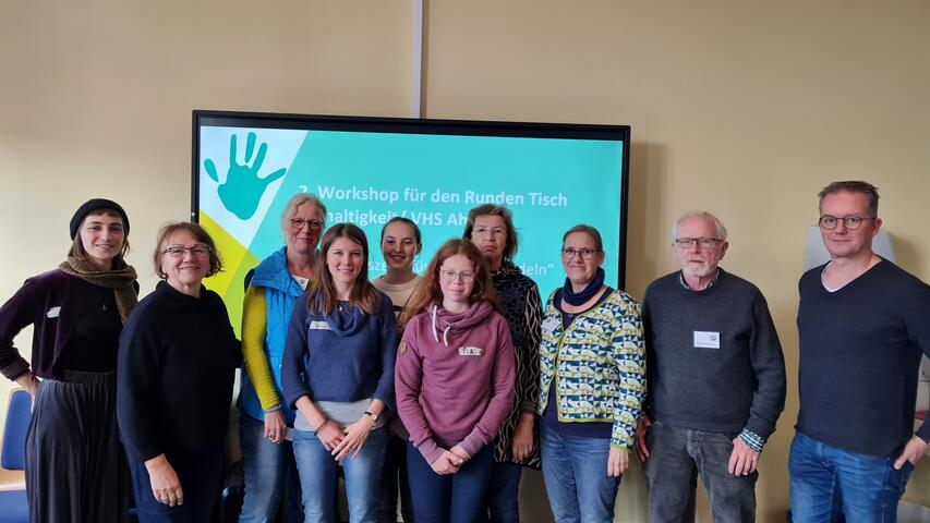 Eine Gruppe Menschen steht vor einem Smart-Board