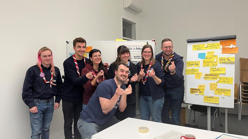 Die Malteser Jugend steht vor einer beschriebenen Flipchart