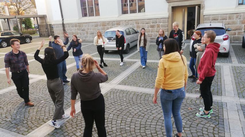 Eine Gruppe der evangelischen Jugend macht eine Übung zu eigenen Ressourcen vor dem Haus.