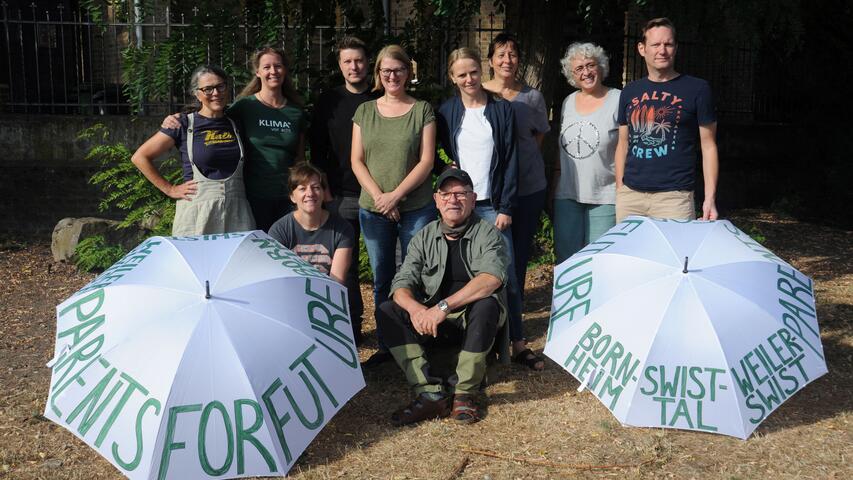 Gruppenfoto mit 2 Regenschirmen, auf denen Demosprüche stehen