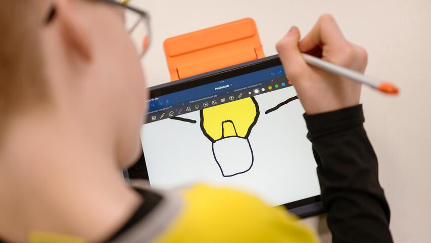 Ein Schüler designt am Tablet eine Idee.